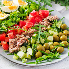 Healthy food. Tuna fish salad with eggs, cucumber, tomatoes, olives and arugula.  French cuisine.