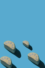 Pattern of tasty marshmallows with hard shadows on a light blue background with copy space