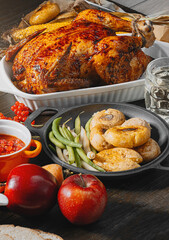 Thanksgiving celebration concept, baked turkey with vegetables on a table with corn, green peas, ripe apples and other vegetables. autumn harvest
