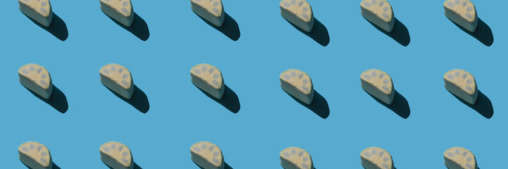 Pattern of tasty marshmallows with hard shadows on a light blue background.