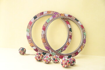 Indian traditional multi-color rhinestone type imitation bangles with hangings to the bangles.