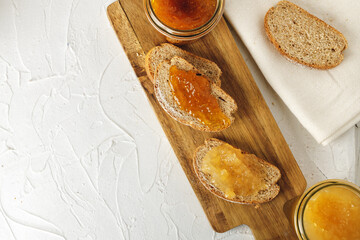 Slice of bread covered with fruit jam on wooden board