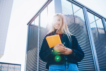 Good looking cheerful smart female student dressed in casual clothes sincerely laughing while...