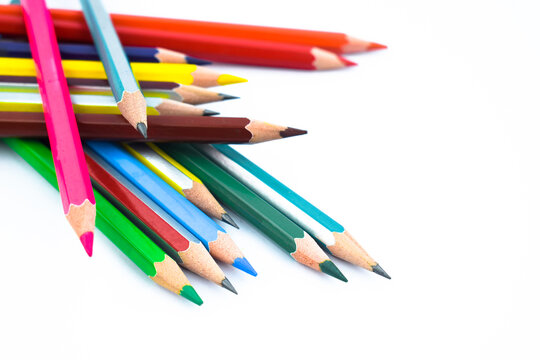 Huge stack of different colored wood pencil crayon placed on a white background