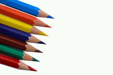 One Line of seven different colored wood pencil crayon places on a white paper