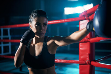 Female fighter hitting small boxing bag.