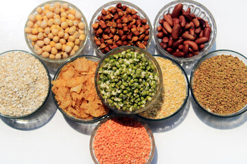 Collection of legumes (chickpeas, green peas, Pink lentils, Indian lentils, red beans, green mung beans, Dry peas, Pigeon Peas, Red Kidney, Fenugreek Seed, Oatmeal) isolated on white background.