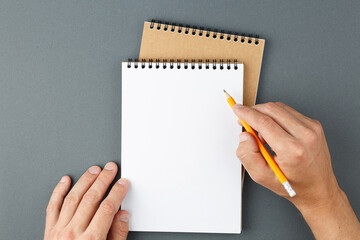 Notebook clear page and male hands with pencil.