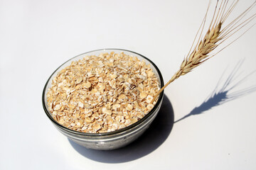 Bowl full of oats. Porridge oats in  cereal bowl on white background. A bowl of whole oats isolated on a white background. Healthy Eating concept-Oat Flakes.