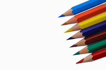 A row of seven different colored wood pencil crayon places on a white paper