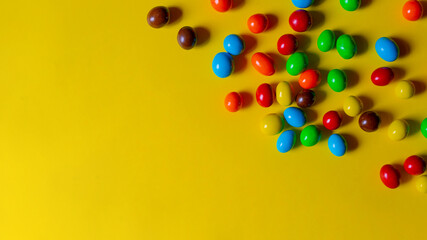 Multi-colored sweets on a yellow background. Copy space.