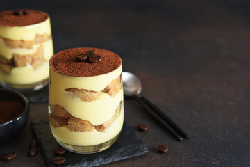 Classic tiramisu in a glass on a dark background.