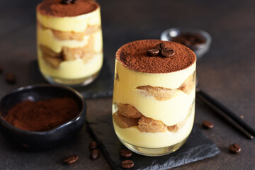 Classic tiramisu in a glass on a dark background.
