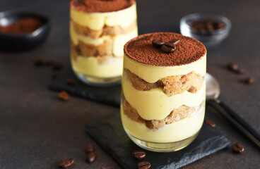 Classic tiramisu in a glass on a dark background.
