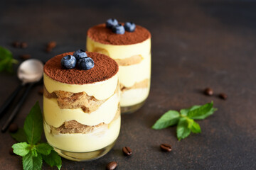 Classic tiramisu in a glass on a dark background.