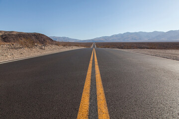 carretera en el desierto del death valley con lineas amarillas
