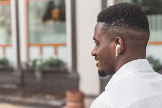 Close-up image of a guy in a profile listening to music via earbuds