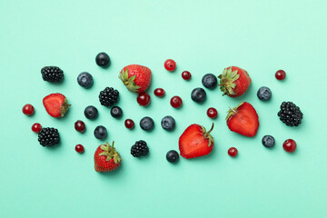 Mix of fresh berries on mint background, top view