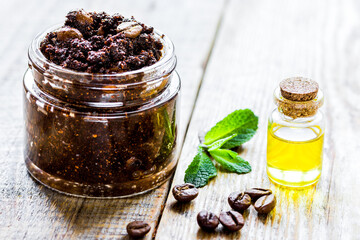 Homemade cosmetics with coffee scrub and oil on wooden desk background