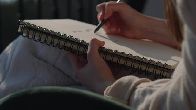 female artist is sketching in sketchbook