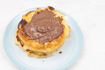 Top view of pancakes with chocolate cream on the plate