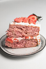 Strawberry cake dessert with fresh cut strawberries on the top for garnish. two layer pink colored cake with white frosting. naked cake style - 364548429