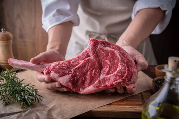butcher serving fresh tomahawk steak meat to customer - Powered by Adobe