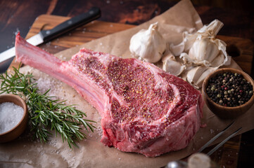 seasoned tomahawk steak meat on wooden board