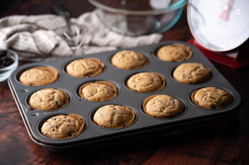 chocolate chip muffin on dark wooden board