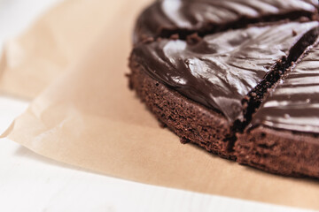  Eight slices of chocolate brownie cake on top of parchment paper on a white table.  - 364551038