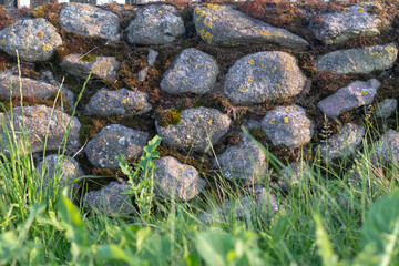 Stone wall background with grass and moss