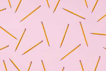 Top view of seamless background of pencils chaotically scattered on pink surface