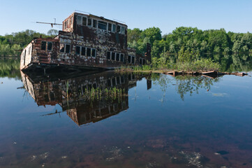 Fototapeta premium Abandoned sunken Barges Boats On River Pripyat in Chernobyl exclusion Zone. Chernobyl Nuclear Power Plant Zone of Alienation in Ukraine