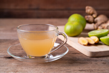 Hot Ginger juice with lime fruit and slices of ginger on cutting board,healthy Drink