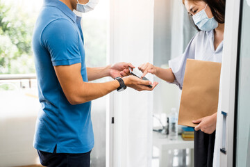 Obraz premium Deliveryman delivering package food order customer at home signing signature on tablet wearing face mask safety covid-19 infection customer delivery service logistics ordering mail posting business