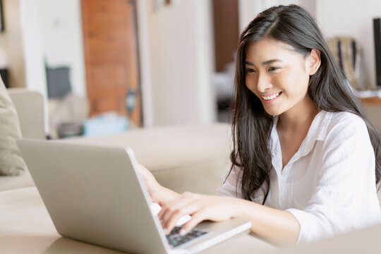 beautiful woman using touching interacting computer laptop working surfing internet resting on sofa hotel room comfortably relaxing smiling enjoying care free time holiday vacation and accommodation