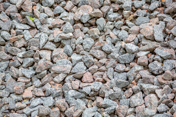 Gray textured surface of a heap of construction pebbles and gravel
