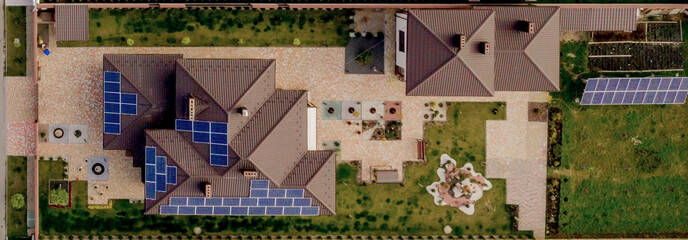 Aerial top view of new modern residential house cottage with blue panels. Renewable ecological...