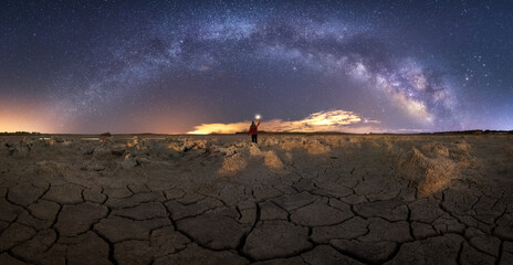 Majestic scenery of volcanic terrain with porous rocks and colorful Milky Way on background