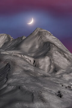 Magnificent view of mountains covered with snow at sunset with the Moon in the sky