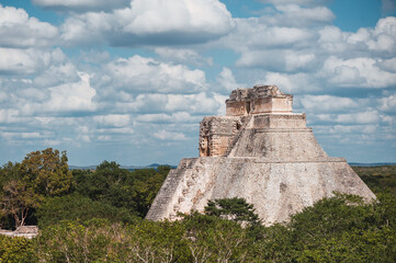 Exterior of stone steps of El Castillo with view of pyramid under cloudy sky in Chichen Itza
