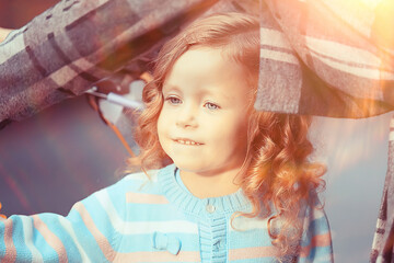 child in a raincoat autumn / autumn view a small child in a raincoat, a park in the city