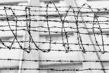 Black and white of spiky barbed wire above fence of local place of criminal confinement in Hong Kong