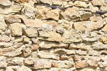 Alte Natursteinmauer historische Steinmauer,  gelb mit Gras und Blumen im Vordergrund