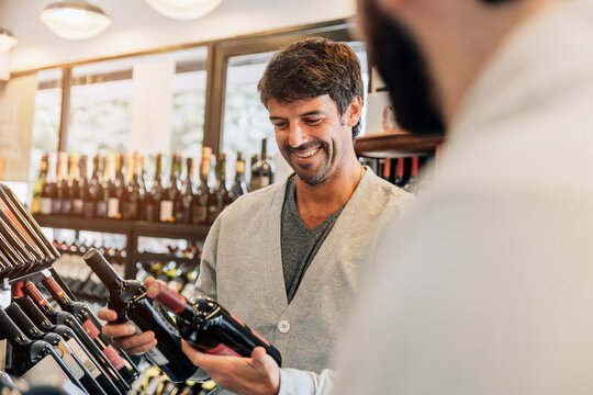 Mid adult man choosing a wine at the supermarket