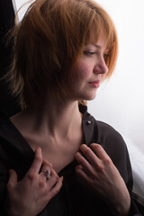 Obraz premium Portrait of a young red-haired woman with a sad expression on white background