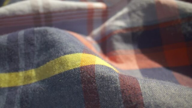 Close-up over a plaid patterned cotton shirt.