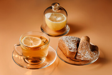 Tea with lemon, curd muffins and lemon on a light background.