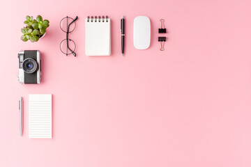 Naklejka premium Overhead shot of modern office desktop with business accessories on pink background with copyspace. Flat lay