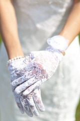 close-up hands of the bride in white lace gloves. selective focus